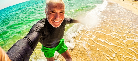 Man taking selfie while standing on surfboard on the beach