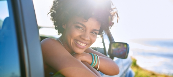 Smiling woman leaning out of a car window