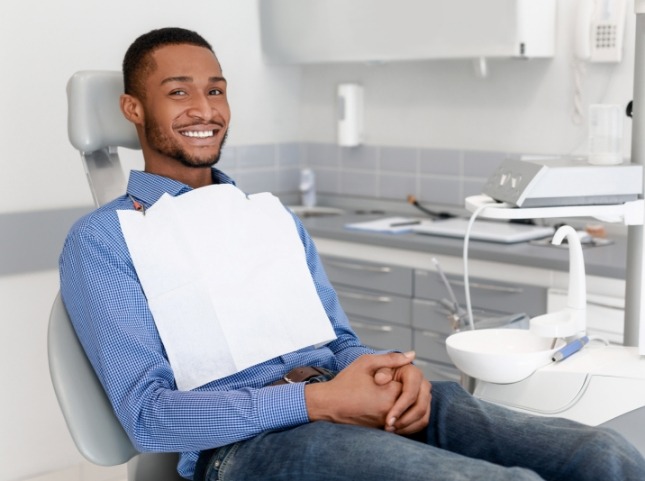 Smiling man sitting patiently in dental chair