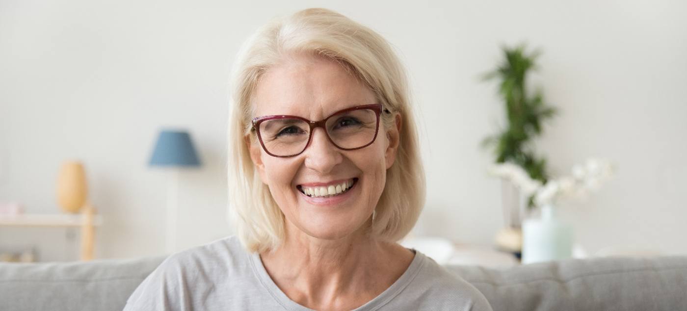 A smiling middle aged mature grey-haired woman looking at camera