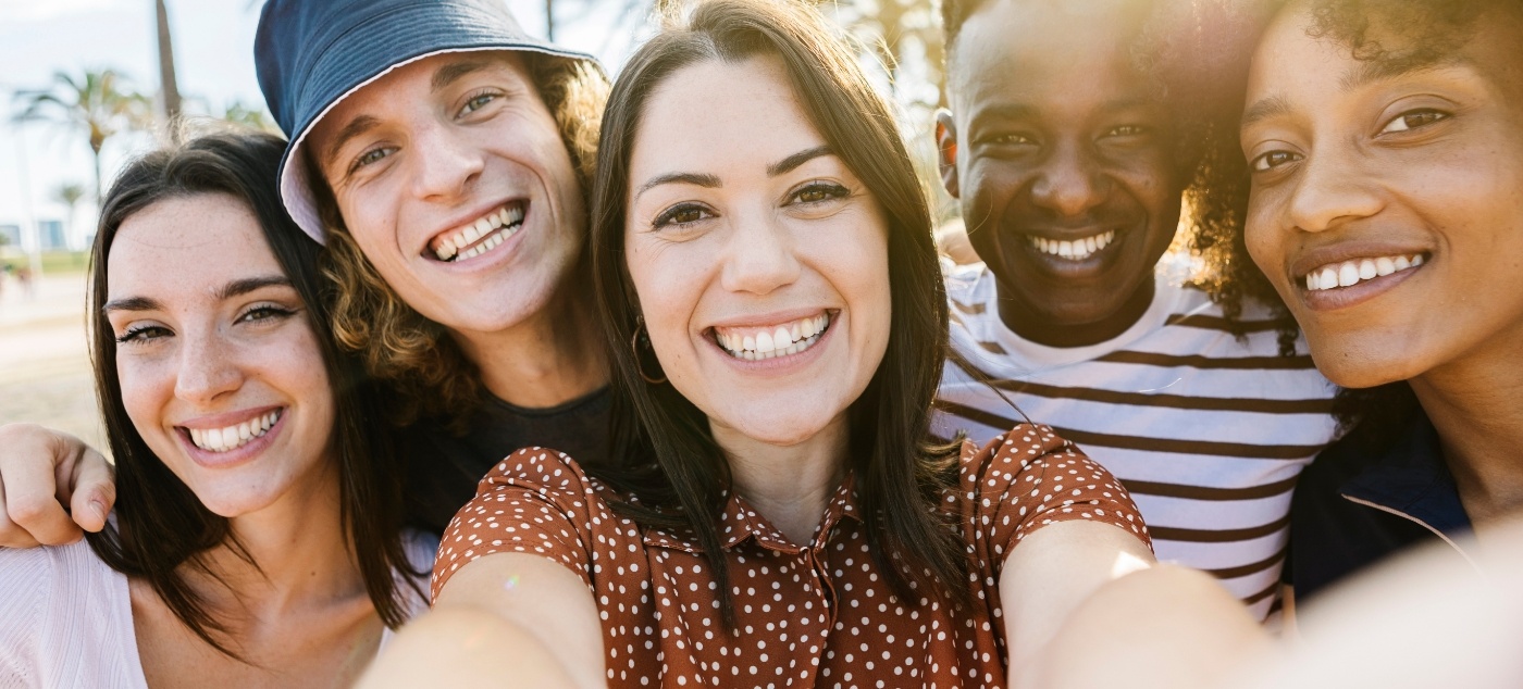Group of people smiling outdoors on sunny day