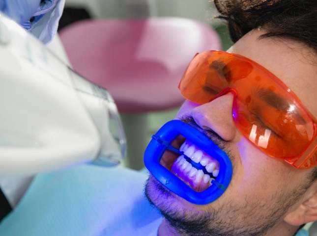 Man in dental chair getting professional teeth whitening