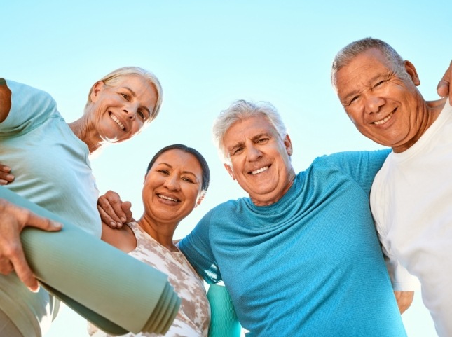 Four adults in exercise clothes outdoors