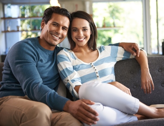 Man and woman sitting on couch and smiling