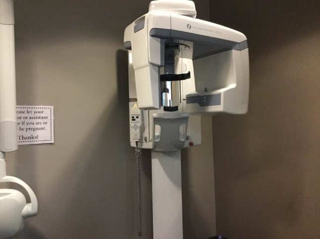 3 D cone beam scanner standing against wall of Newark dental office
