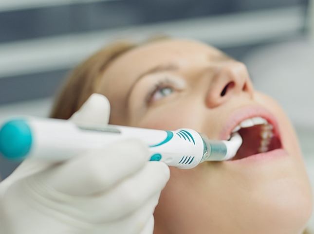 Dentist using a thin scanner on a patient