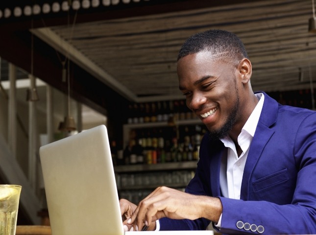 Smiling man typing on laptop