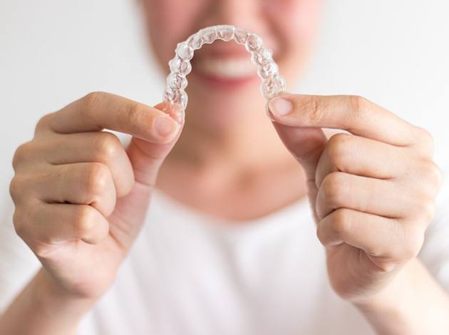 Closeup of patient putting on clear aligner