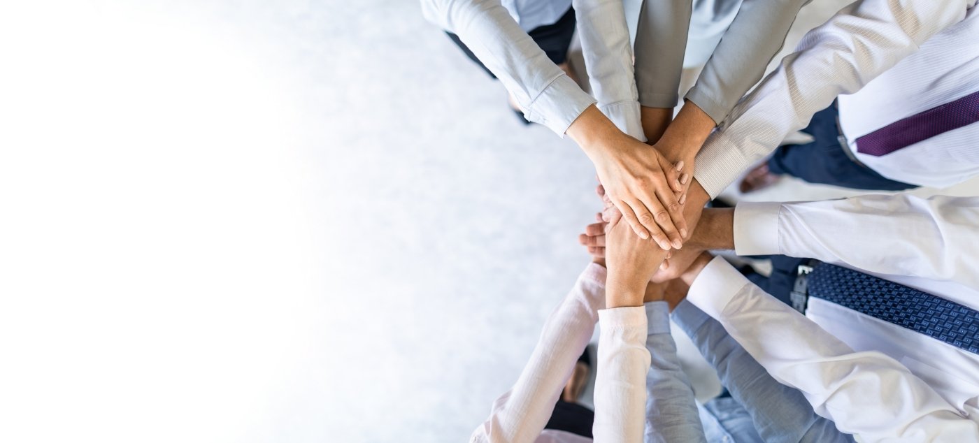 Circle of dentists placing their hands in the middle