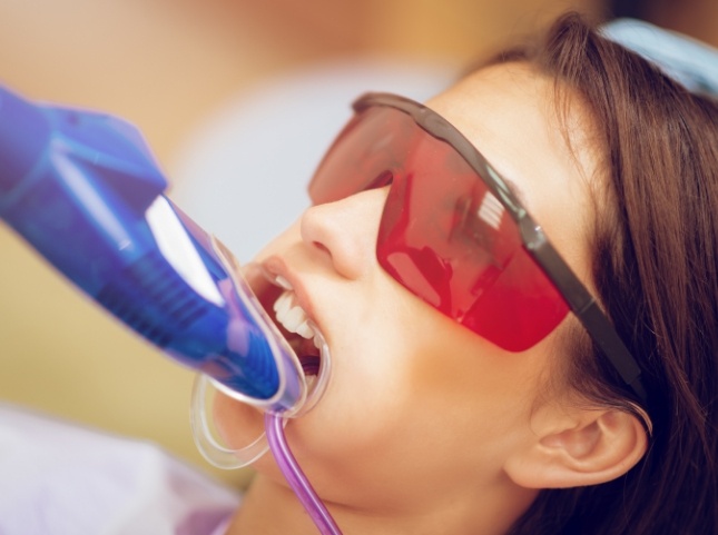 Young dental patient with fluoride trays on her teeth