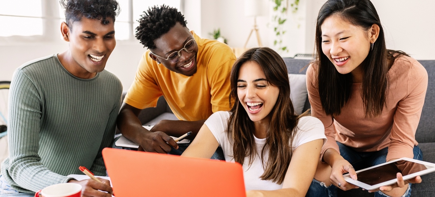 Young adults looking at laptop for dentist reviews in Newark