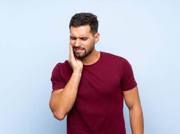 Grimacing man dealing with mouth pain