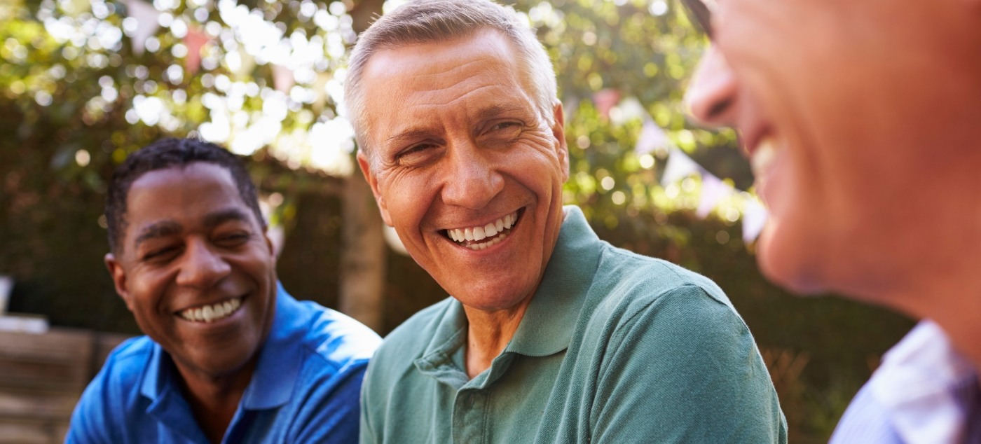 Group of men laughing together outdoors after sedation dentistry in Newark