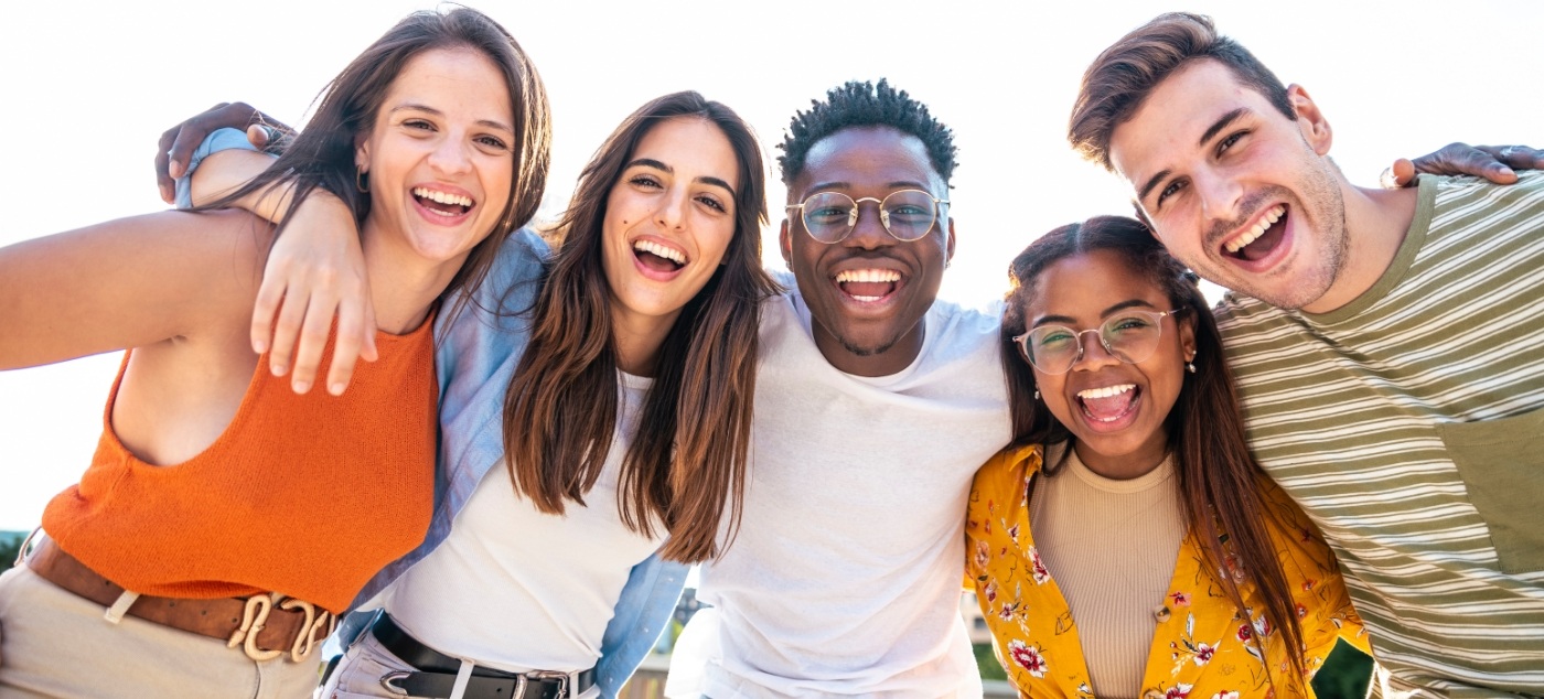 Young adults smiling together after wisdom tooth extractions in Newark